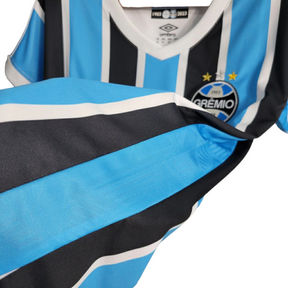 Camisa Grêmio I 23/24 - Torcedor Umbro Feminina - Azul com listras pretas e brancas